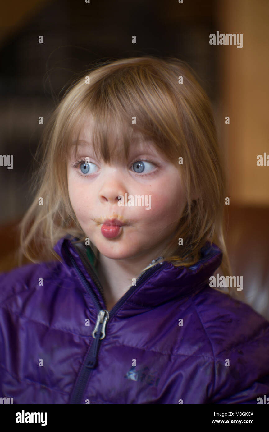 Candid Portrait Of A Young Girl With Blond Hair And Blue Eyes
