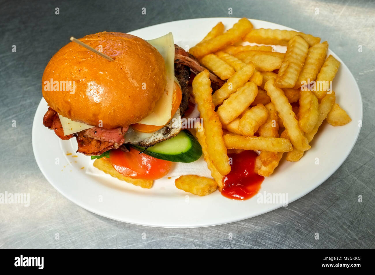 Aussie burger with a side of French fries. Stock Photo