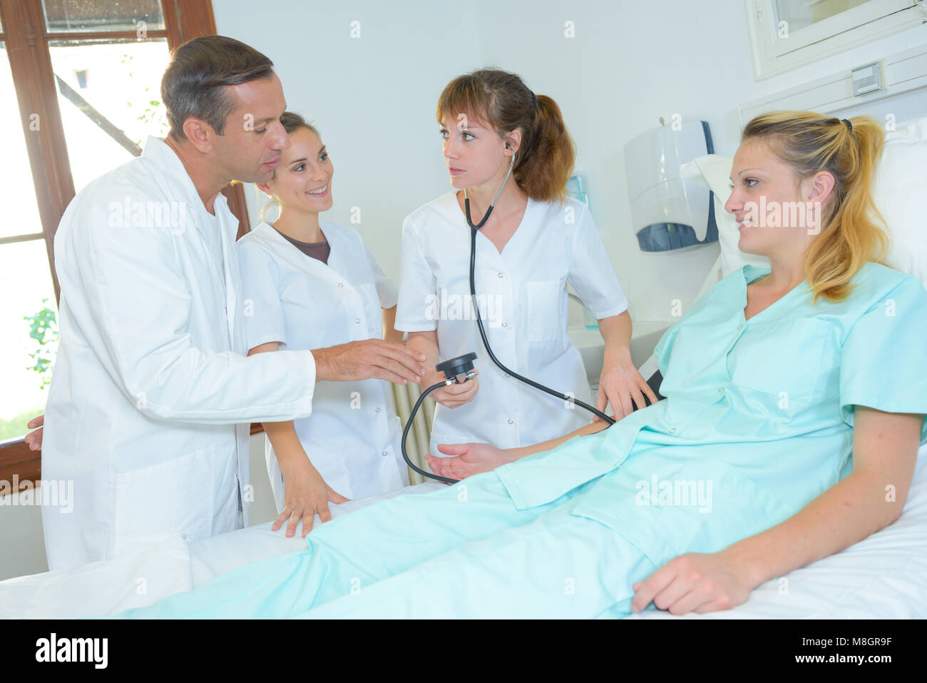 Medical staff taking patient's blood pressure Stock Photo