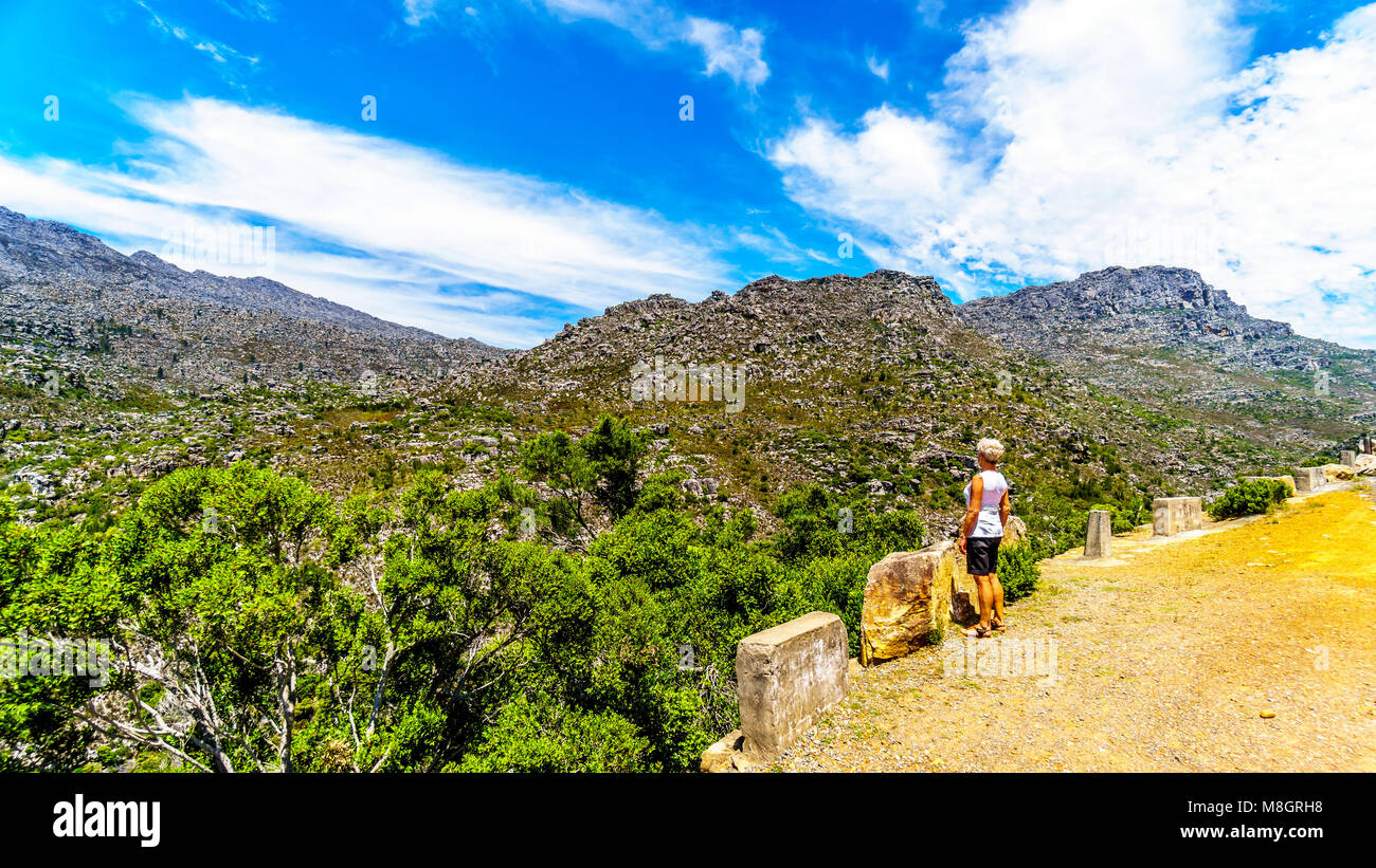 Senior Woman looking at the Slanghoekberge Mountains from the scenic Bainskloof Pass between the towns Ceres and Wellington in the Western Cape provin Stock Photo