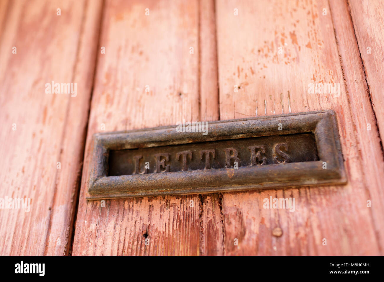 Brass letters box on rustic ochre wooden door in village of Roussillon, Provence, France Stock Photo