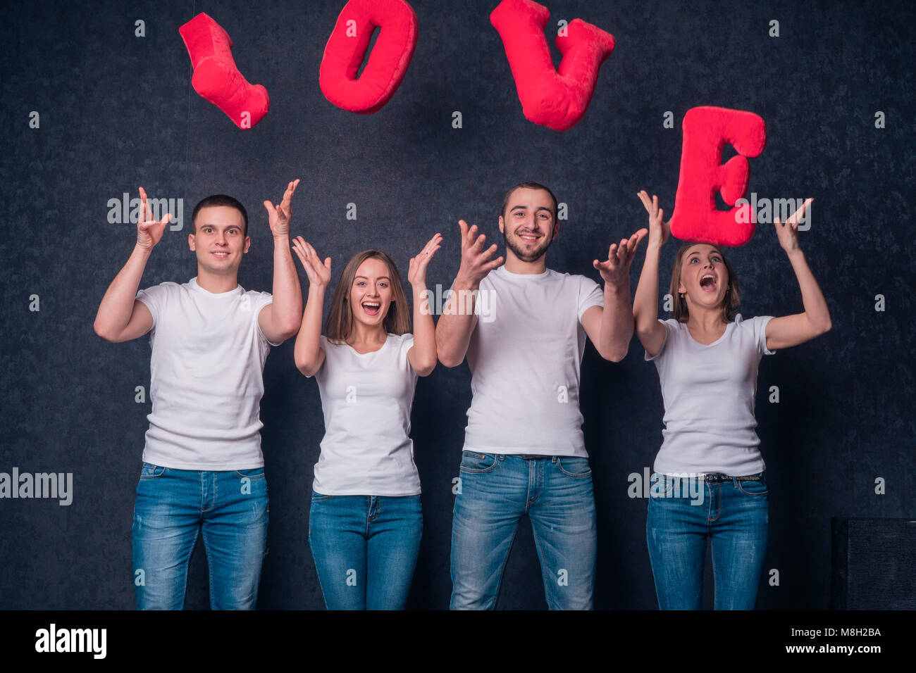 Courting couples throw up in the air the letters of the word Love Stock Photo