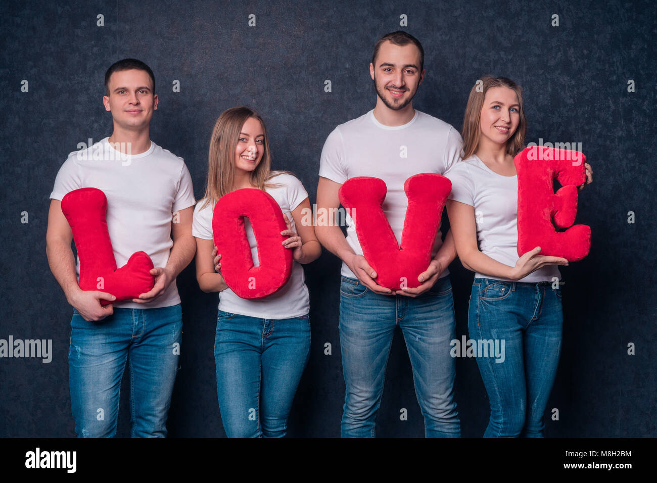 young people, friends make up the word 'Love' from plush letters Stock Photo