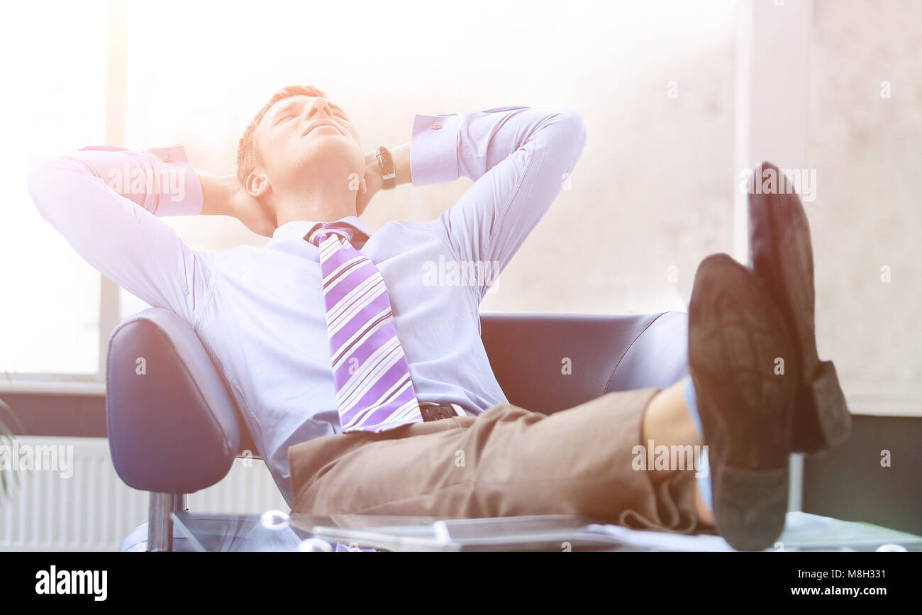 Young businessman leaning back in his chair Stock Photo Alamy