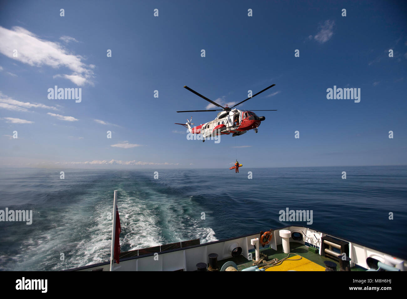 HM Coastguard Sikorsky helicopter carries out a training rescue in the Minch over the Caledonian Macbrayne Ulapool to Stornoway ferry. Stock Photo
