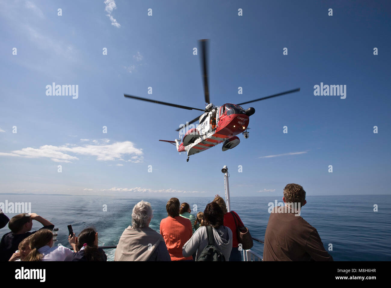 HM Coastguard Sikorsky helicopter carries out a training rescue in the Minch over the Caledonian Macbrayne Ulapool to Stornoway ferry. Stock Photo