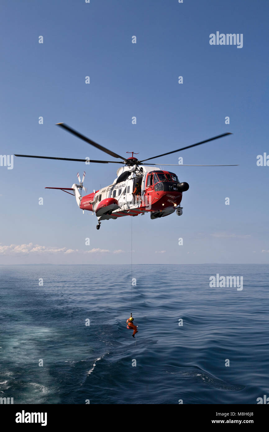 HM Coastguard Sikorsky helicopter carries out a training rescue in the Minch over the Caledonian Macbrayne Ulapool to Stornoway ferry. Stock Photo