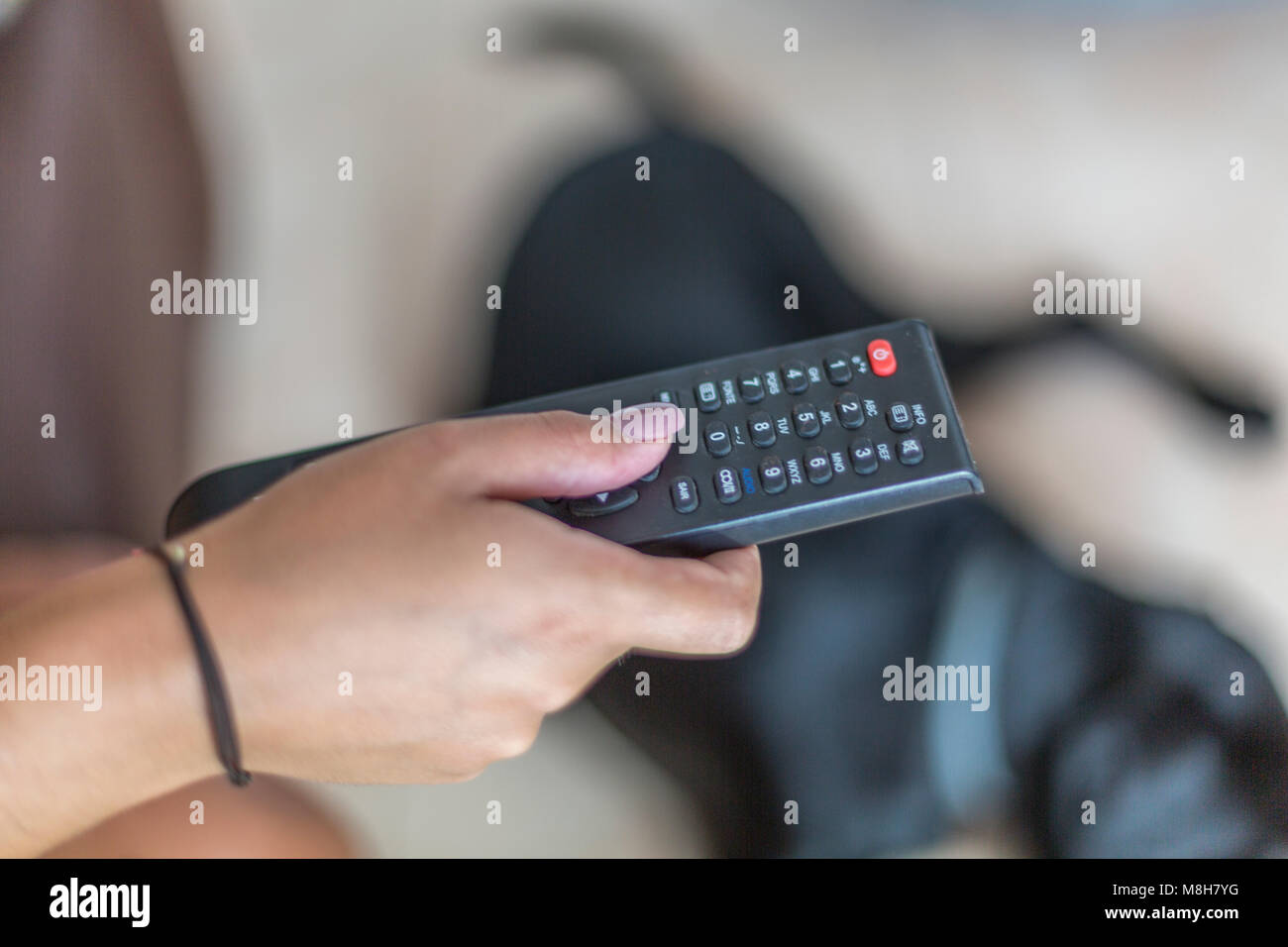 female hand, changing television channel with remote control Stock Photo