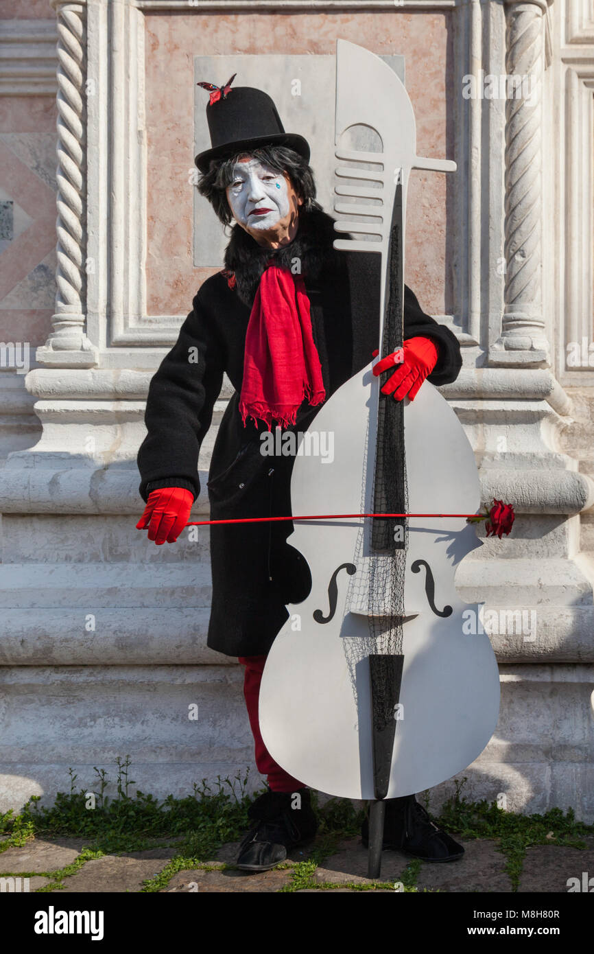 A pierrot or Pierot sad clown character from commedia dell'arte in fancy dress costume, playing a base at Venice Carnival, Carnivale di Venezia, Italy Stock Photo