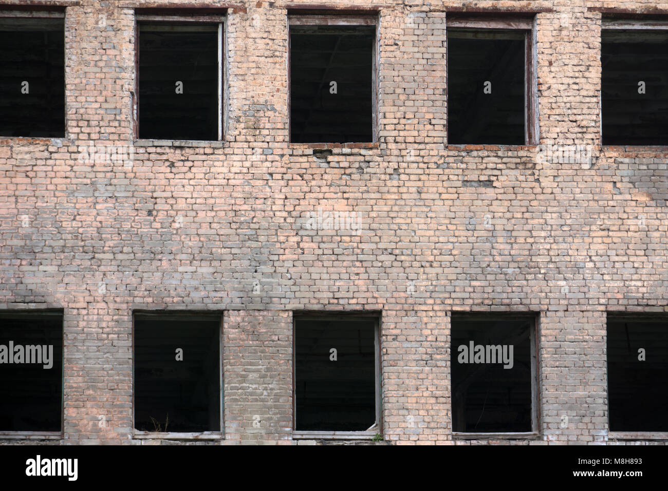 Brick facade of an abandoned old building with windows Stock Photo - Alamy
