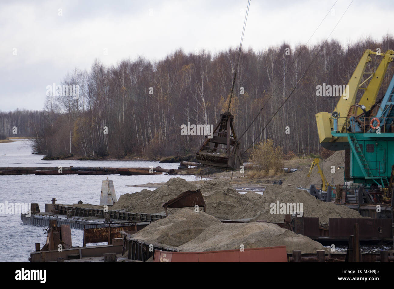 crane unloading a barge filled with sand, closeup of shovel Stock Photo Alamy