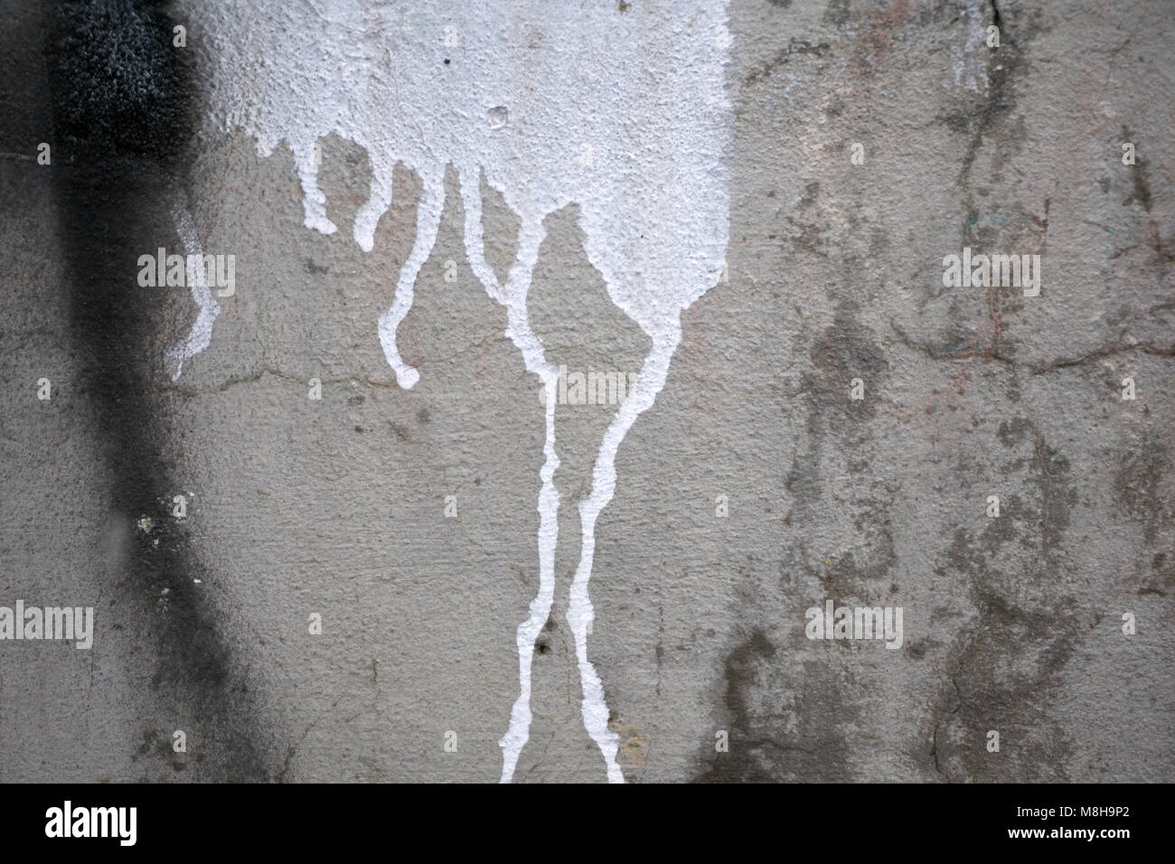 Texture of grey concrete wall with dark water marks running vertically