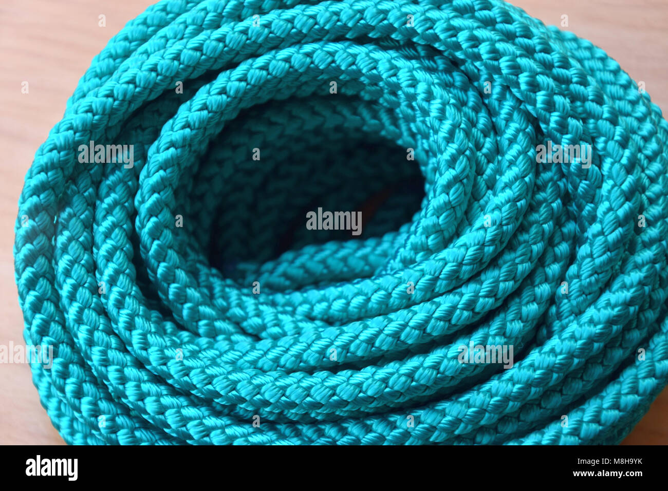 roll of nylon rope in turquoise color and wooden background Stock Photo -  Alamy