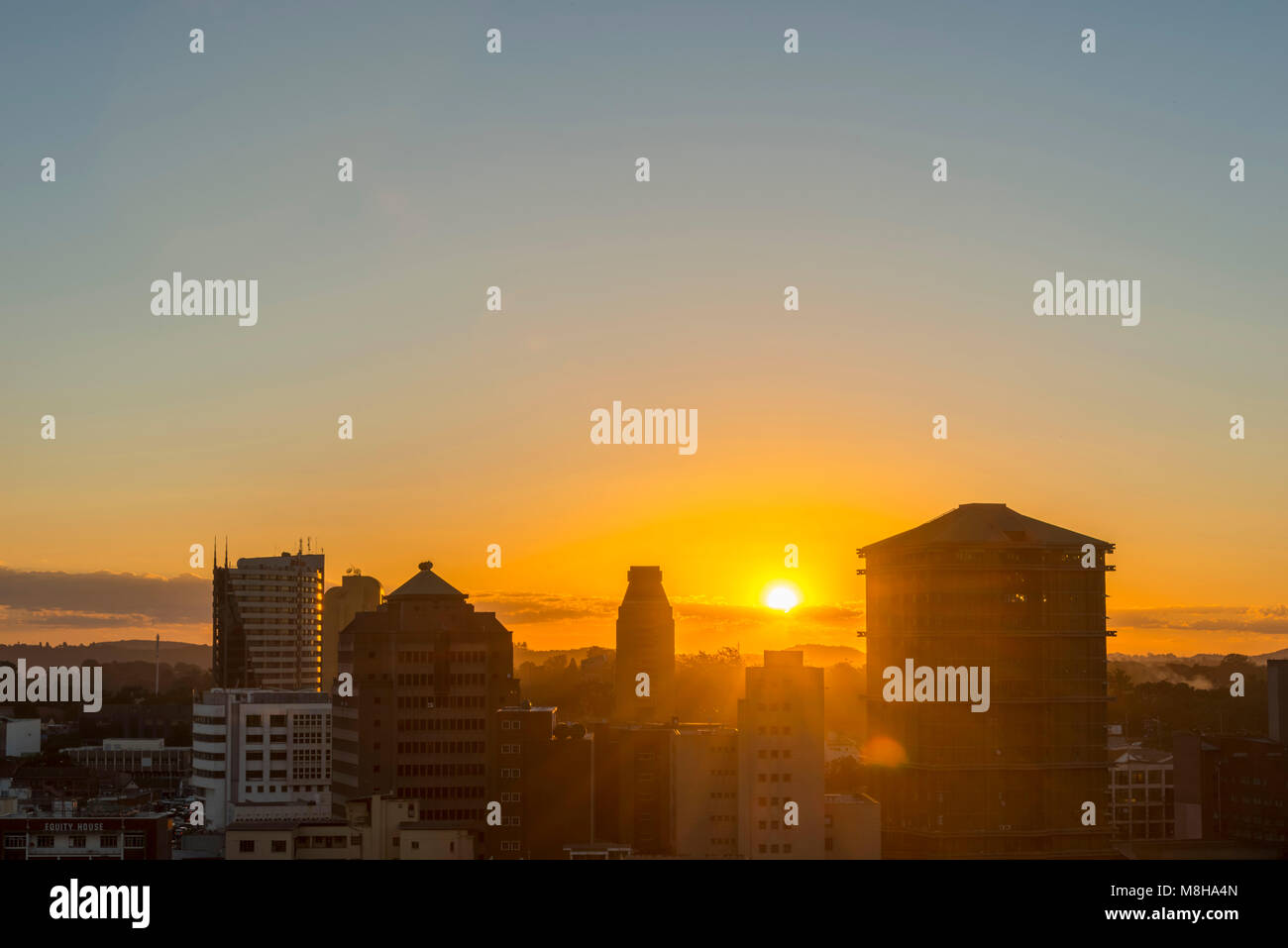 Sun setting behind city buildings hi-res stock photography and images ...