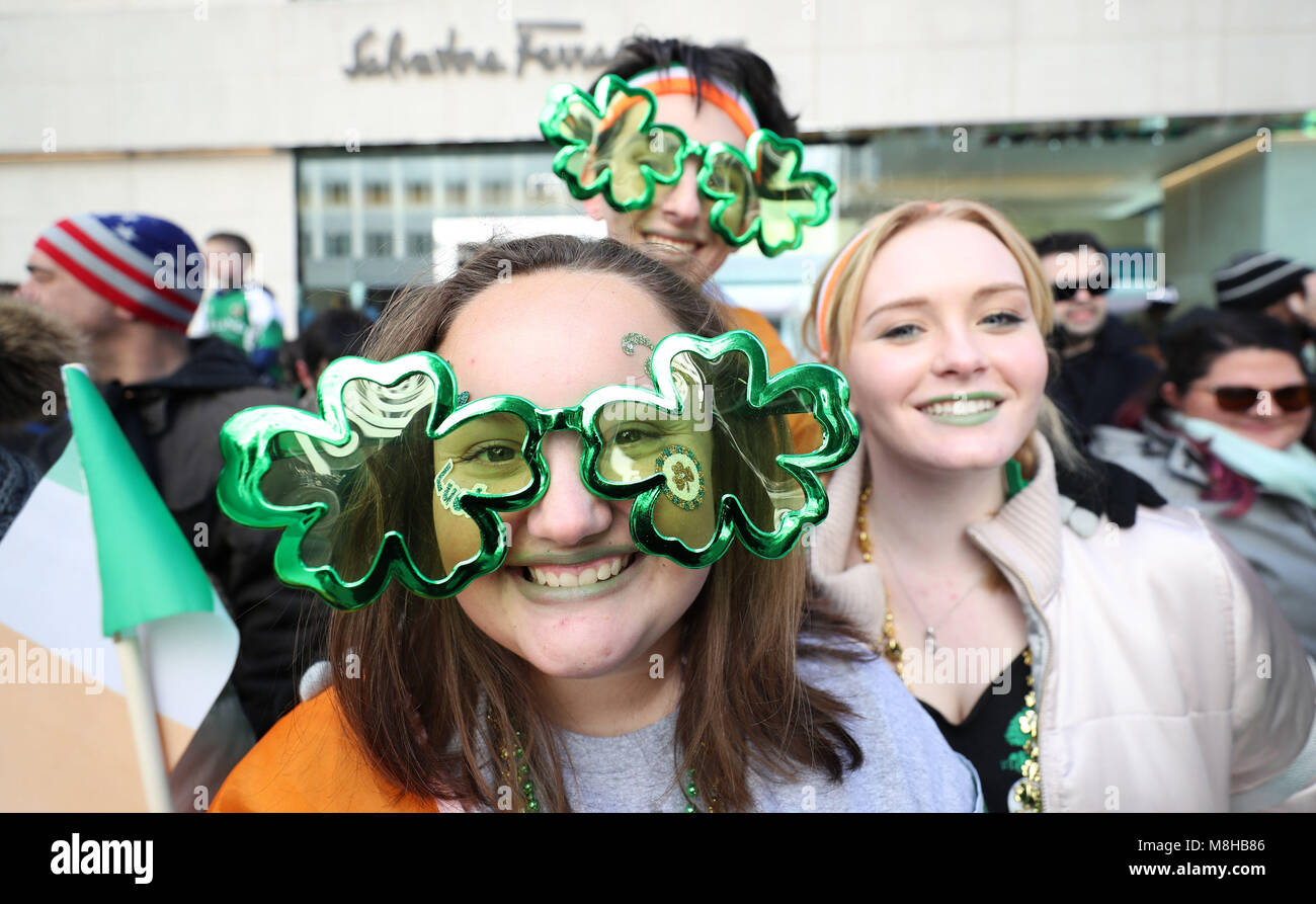 Revellers watch the St Patrick's Day parade in New York City. Stock Photo