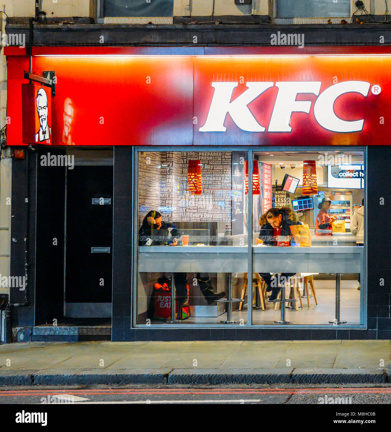 Exterior of a Kentucky Fried Chicken - KFC restaurant at night on Earl's Court Road, London, England, UK Stock Photo