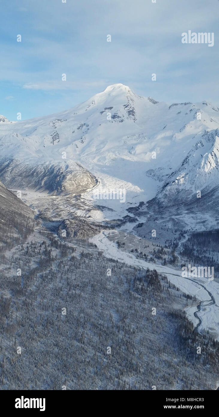 Iliamna in January. Iliamna rises above braided rivers and frozen tundra in this January aerial Stock Photo