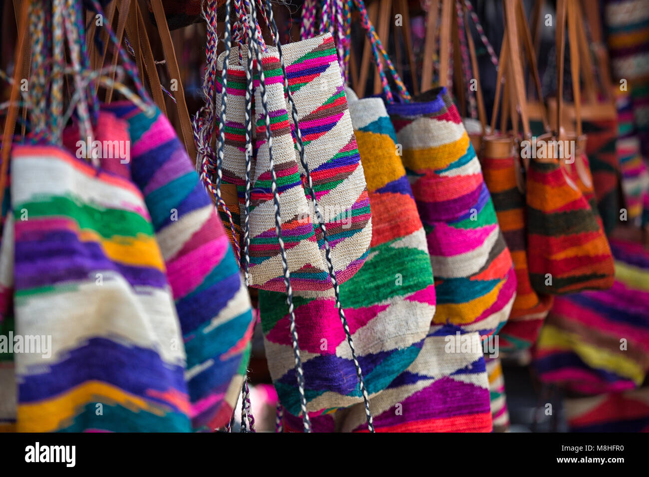 Otavalo, Ecuador - March 10, 2018: closeup of colourful indigenous handbags made of natural fiber in the local artisan market Stock Photo