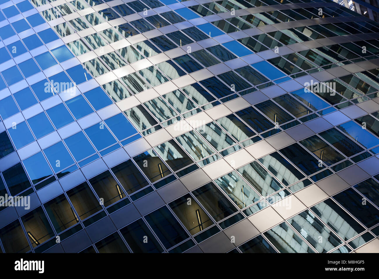 Closeup of modern building with refection of nearby skyscrapers Stock Photo