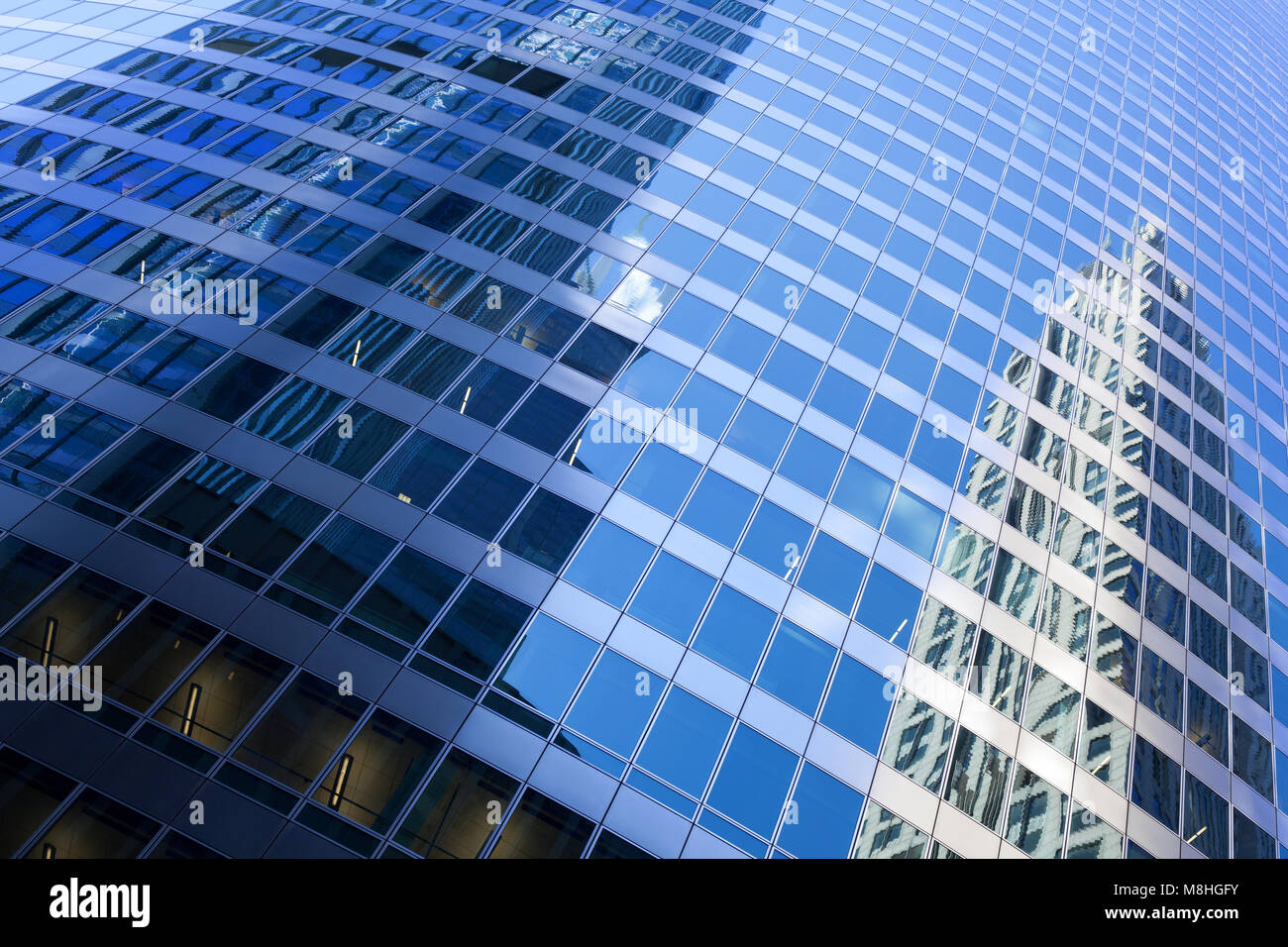 Closeup of modern building with refection of nearby skyscrapers Stock Photo
