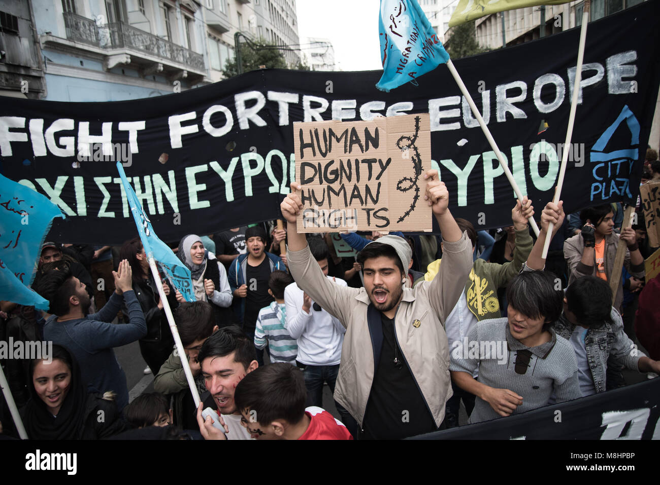 Athens, Greece. 17th Mar, 2018. Protesters hold placards and flags and shout slogans against racism.Mass participation in the anti-fascist demonstration in Athens. Anti-racist and anti-fascist collectivities and organizations, with a central slogan ''never again fascism, '' were headed to the offices of the European Union. They also called for slogans on equal rights for refugees, open borders, asylum and the right to live in any country they decide on themselves. Credit: Vangelis Evangeliou/SOPA Images/ZUMA Wire/Alamy Live News Stock Photo