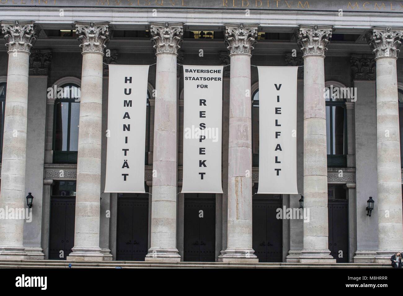 Munich, Bavaria, Germany. 17th Mar, 2018. The Residenz Theatre hangs banners reading ''Humanity, Respect, diversity''. Protesting against the arrival of Pegida Dresden's Lutz Bachmann and Sigfried Daebritz in Munich, no less than three demonstrations were organized by the city, including a Muenchen ist Bunt and Bellevue di Monaco protest at Max Joseph Platz. At this demonstration, choirs were in attendance, along with celebrities, politicians, and other prominent Muenchners dressed as doctors in order to tell Pegida that they will help them go back to Dresden. Participants: Syrischer Fri Stock Photo