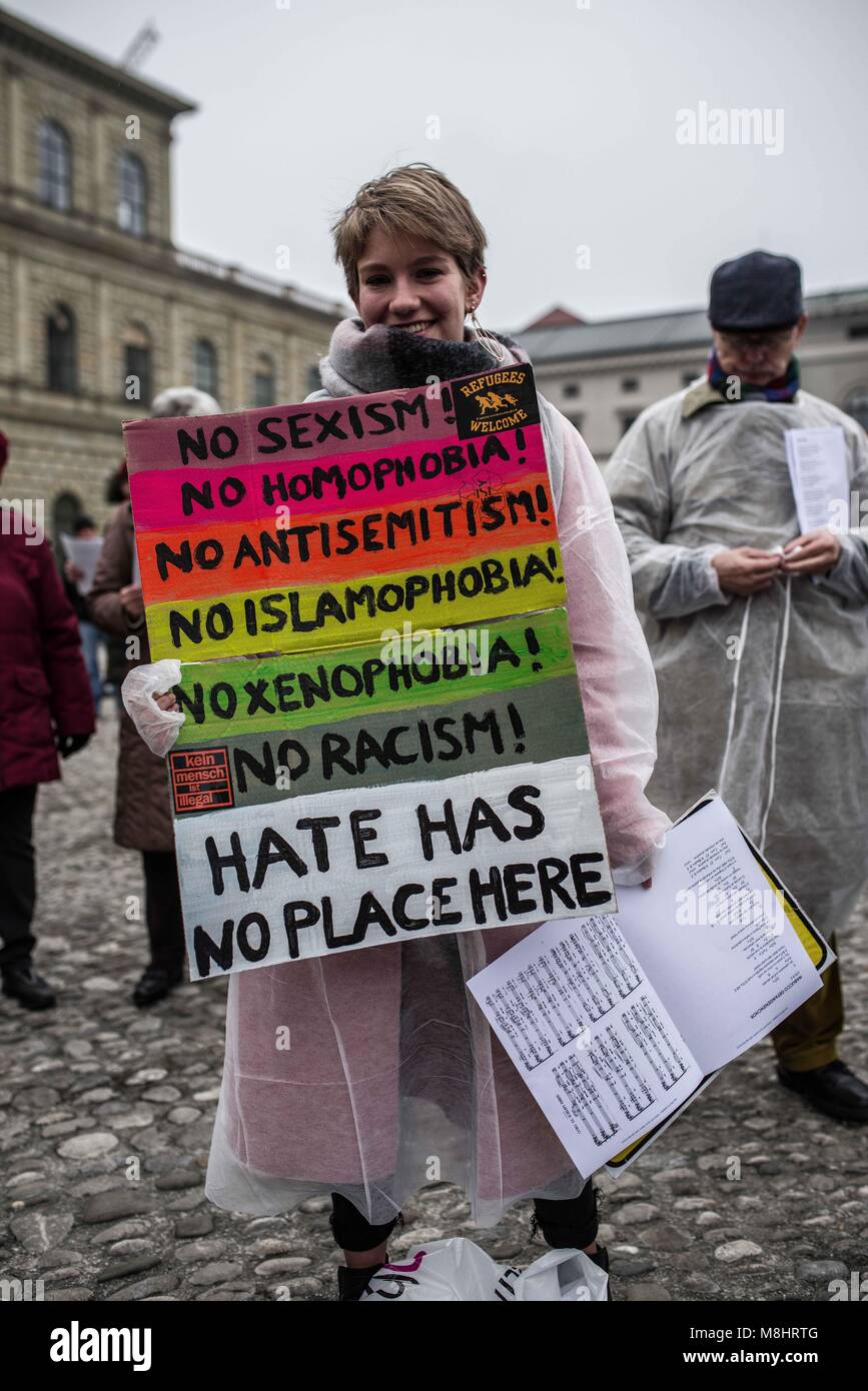 Munich, Bavaria, Germany. 17th Mar, 2018. A young protestor who has been the target of far-right harassment holds a sign against hate. Protesting against the arrival of Pegida Dresden's Lutz Bachmann and Sigfried Daebritz in Munich, no less than three demonstrations were organized by the city, including a Muenchen ist Bunt and Bellevue di Monaco protest at Max Joseph Platz. At this demonstration, choirs were in attendance, along with celebrities, politicians, and other prominent Muenchners dressed as doctors in order to tell Pegida that they will help them go back to Dresden. Participant Stock Photo