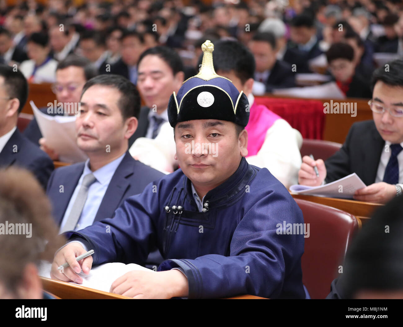 (180318) -- BEIJING, March 18, 2018 (Xinhua) -- Wu Yunbo, a newly-elected deputy to the 13th National People's Congress (NPC), attends the opening meeting of the first session of the 13th NPC at the Great Hall of the People in Beijing, capital of China, March 5, 2018. Wu Yunbo of Mongolia ethnic group comes from Dongsala Village of Jarud Qi (County) of north China's Inner Mongolia Autonomous Region. As a secretary of the Communist Party of China local branch in the Dongsala Village, he initiated a cooperative in 2013 and explored a way to get people out of poverty. Farmers and herdsmen were Stock Photo