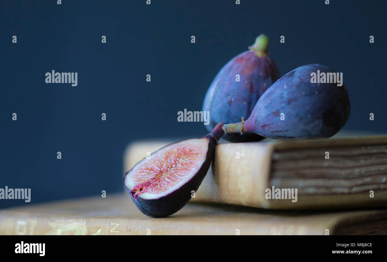 Ripe Figs Positioned on Top of Antique Books Stock Photo
