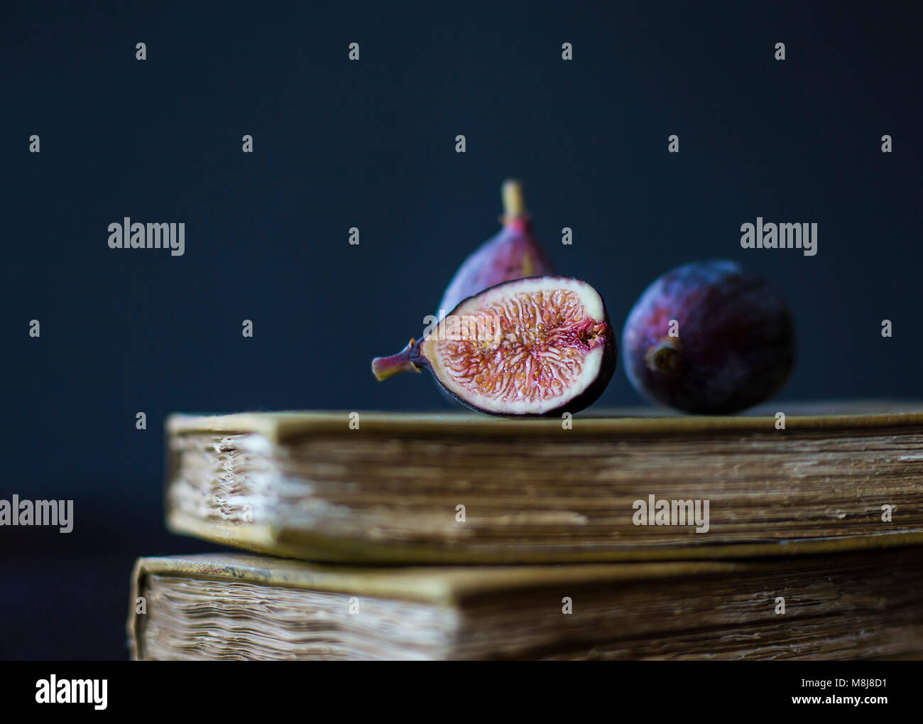 Ripe Figs Positioned on Top of Antique Books Stock Photo