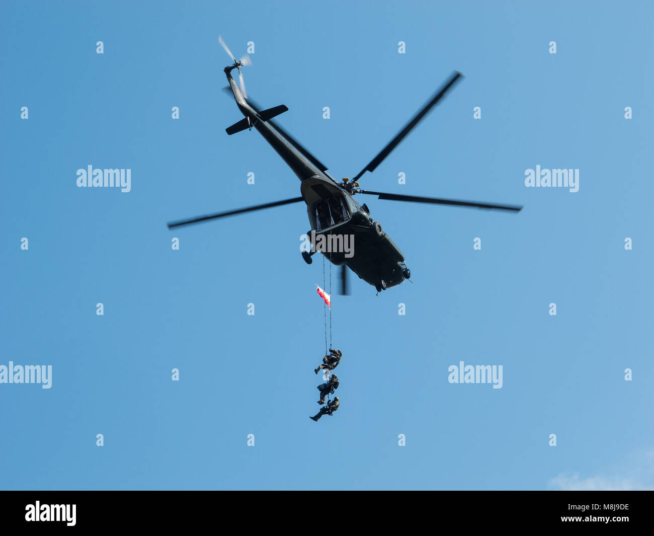 Polish GROM Special Forces show off their skills hanging on ropes from a helicopter. WARSAW, POLAND - SEPTEMBER 13, 2014 Stock Photo