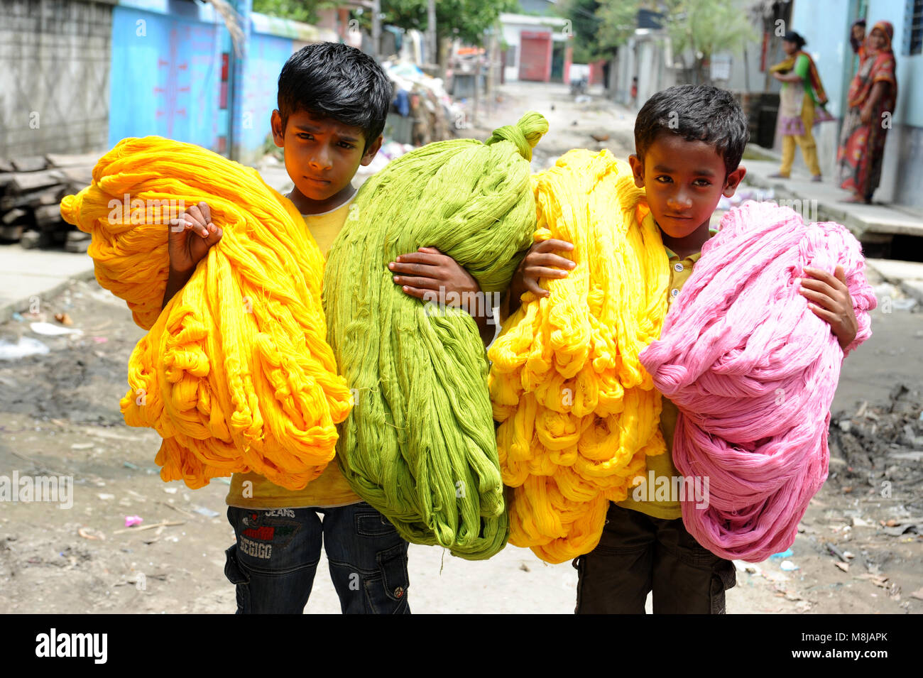 NARAYANGANJ, BANGLADESH - AUGUST 24, 2016: A Bangladeshi boy carring dries Jamdani cotton at Narayanganj, Bangladesh, August 24, 2016. Jamdani is one  Stock Photo