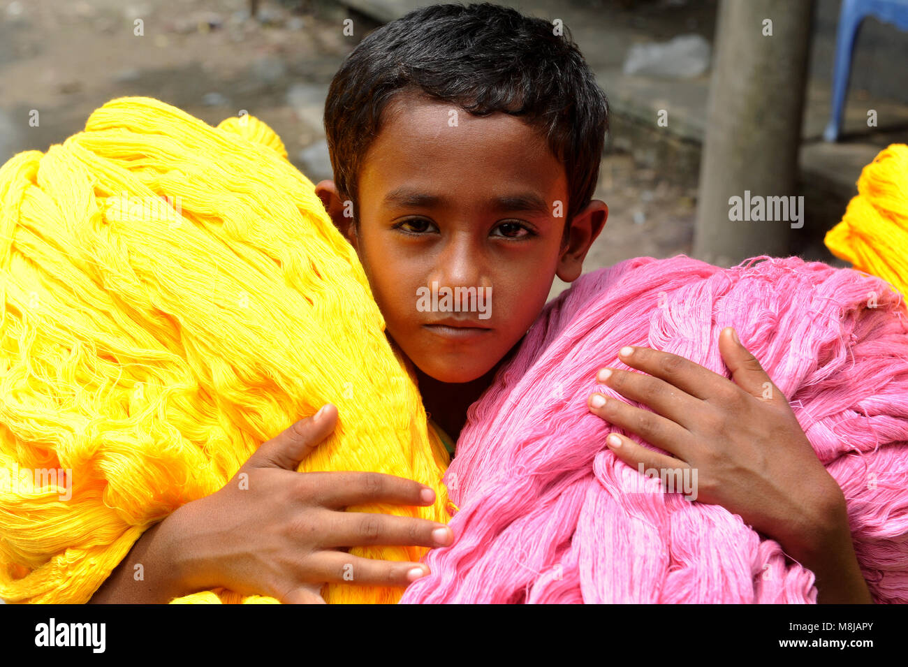 NARAYANGANJ, BANGLADESH - AUGUST 24, 2016: A Bangladeshi boy carring dries Jamdani cotton at Narayanganj, Bangladesh, August 24, 2016. Jamdani is one  Stock Photo