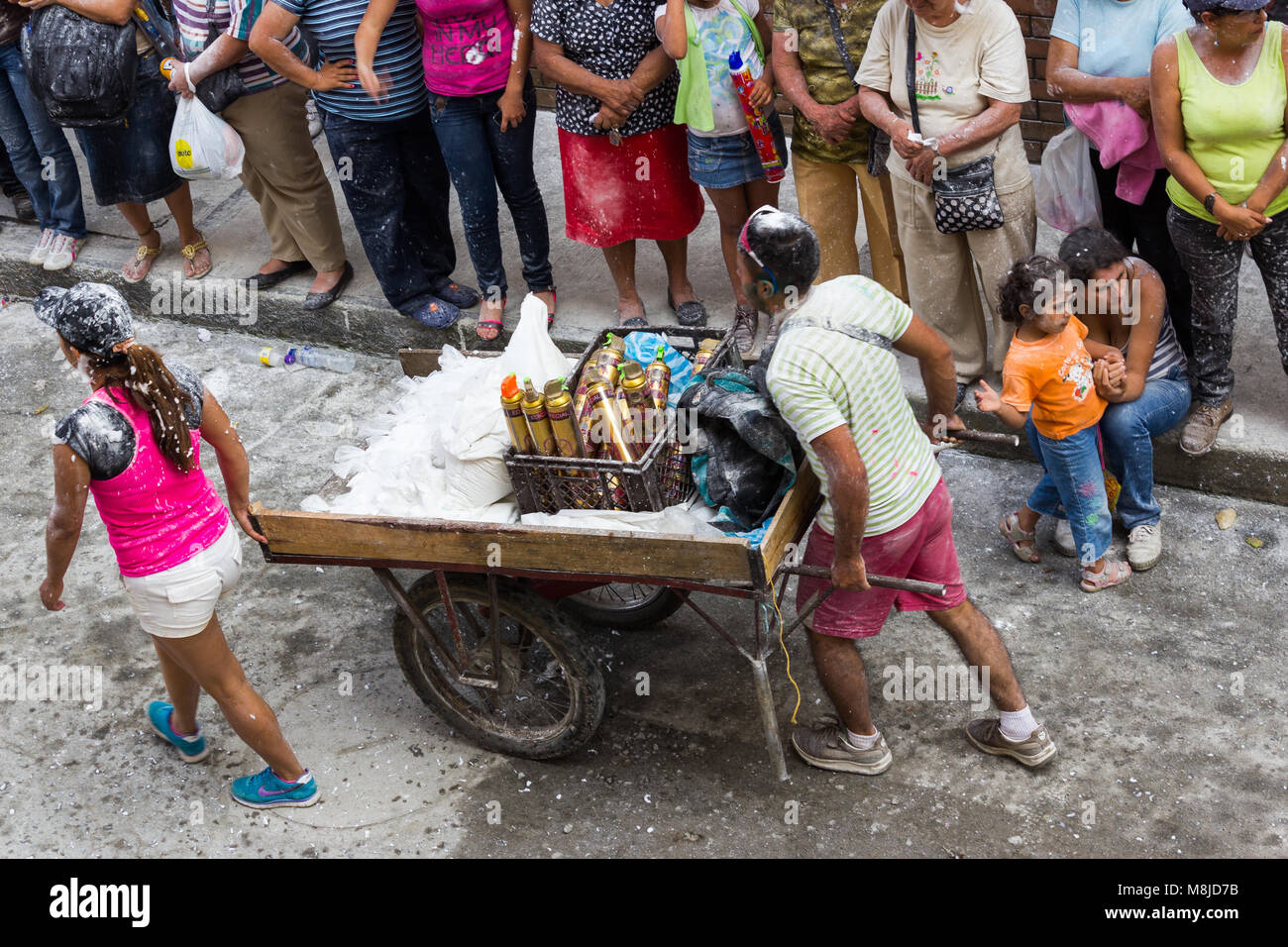 View from above of two people with a cart selling foam and flour at the Carnival de Negros y Blancos in Popayán, Colombia Stock Photo