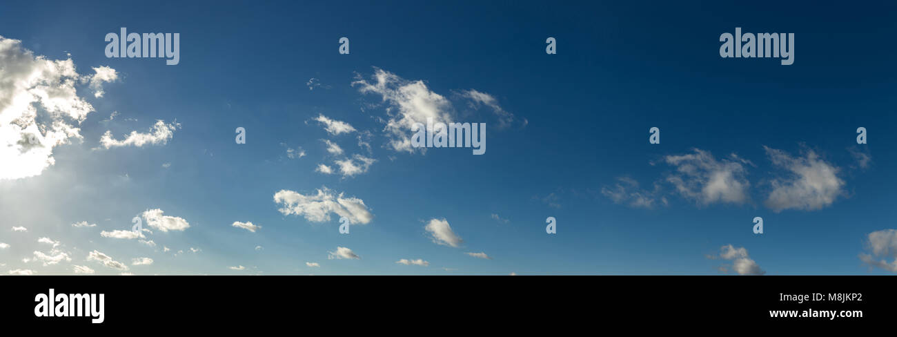 Blue sky panorama background with some small clouds Stock Photo - Alamy