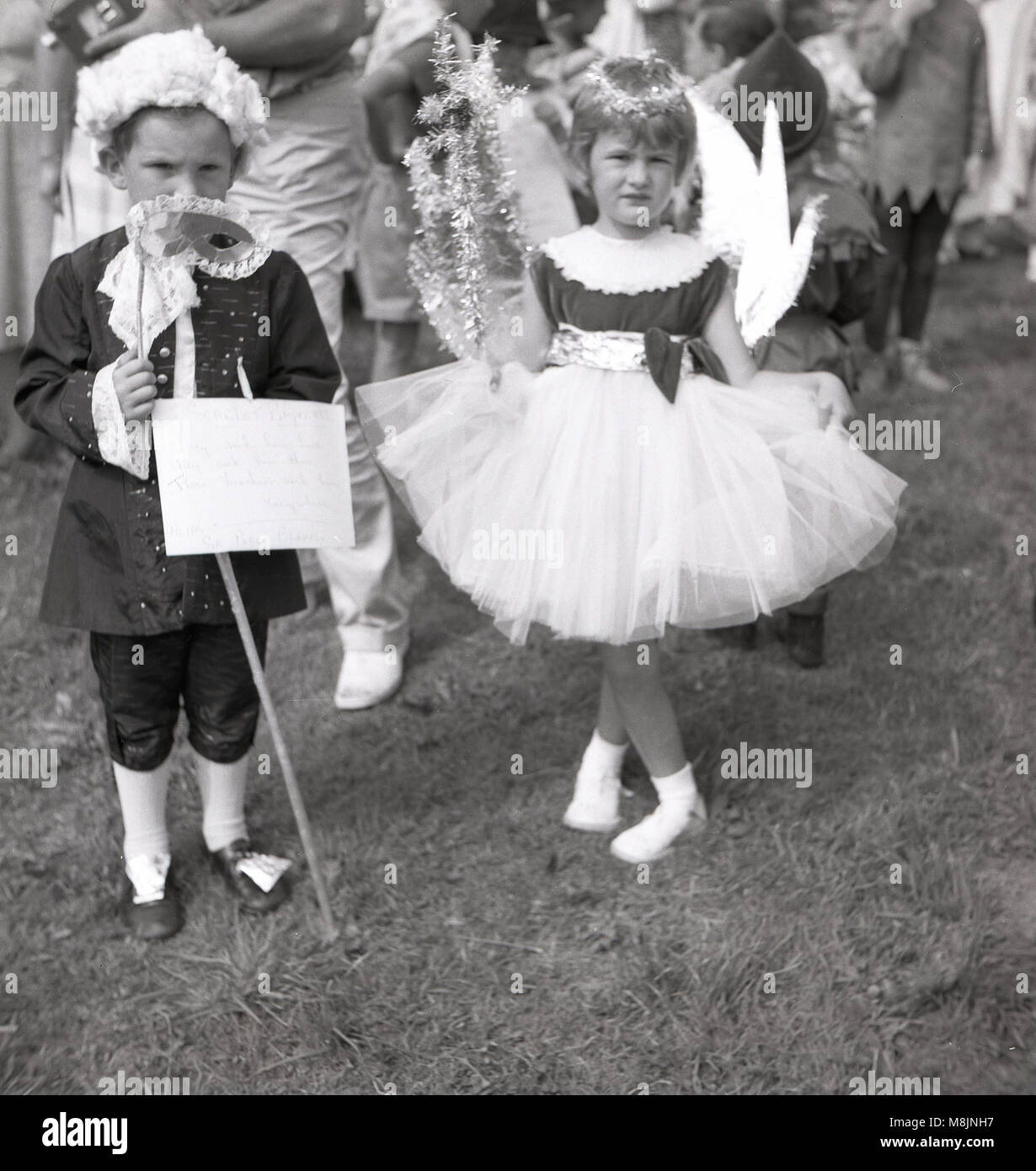 1950s, historical, two young children, a boy and girl taking part in a fancy dress competition at an outdoor fete stand together in their costumes, England, UK. Stock Photo