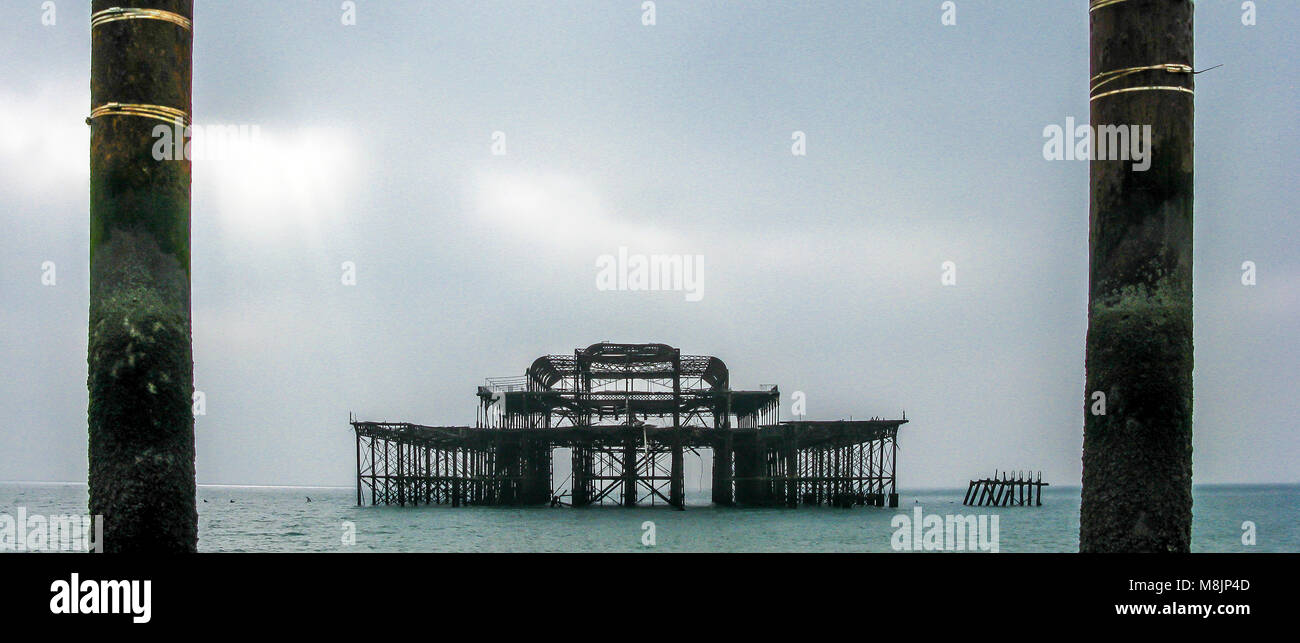 Skeletal cast iron frame of the burnt out West Pier in Brighton ominously  still stands stoically after being left to decay for over 30 years Stock Photo