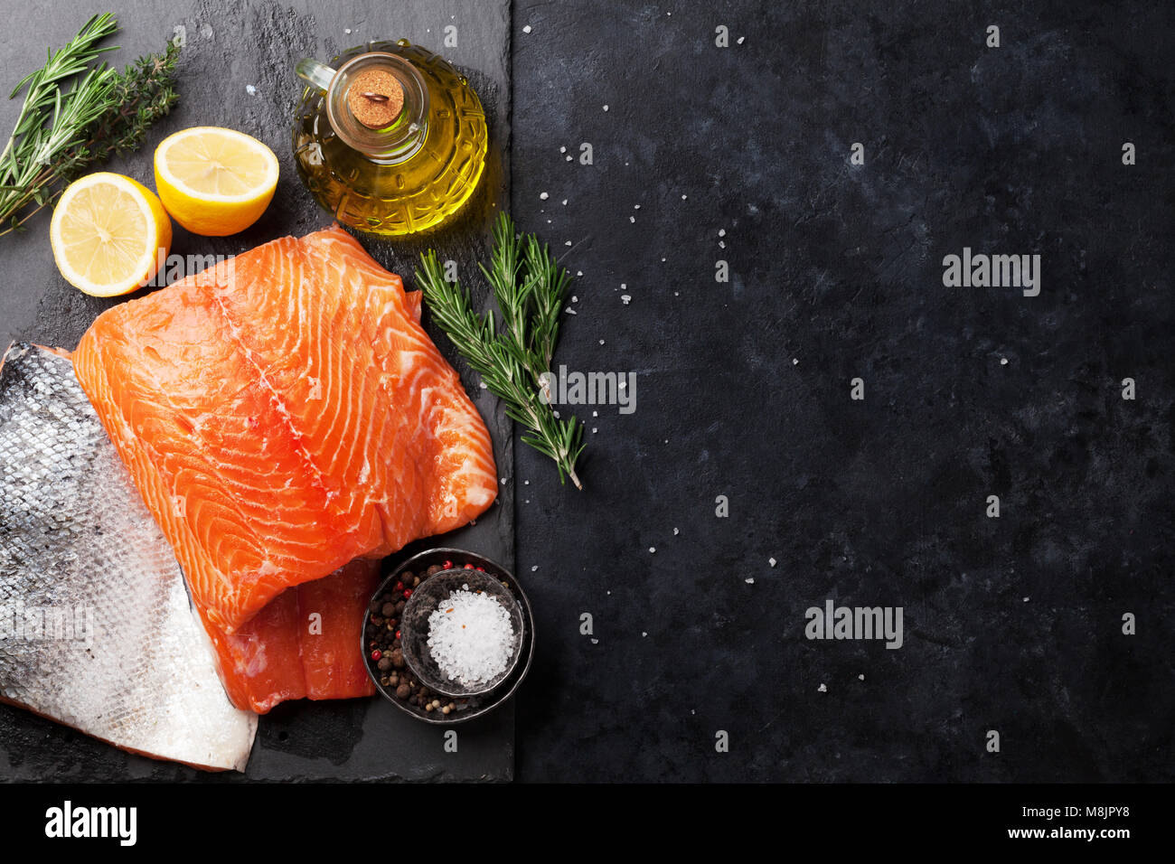 Raw salmon fish fillet with spices cooking on cutting board. Top view ...