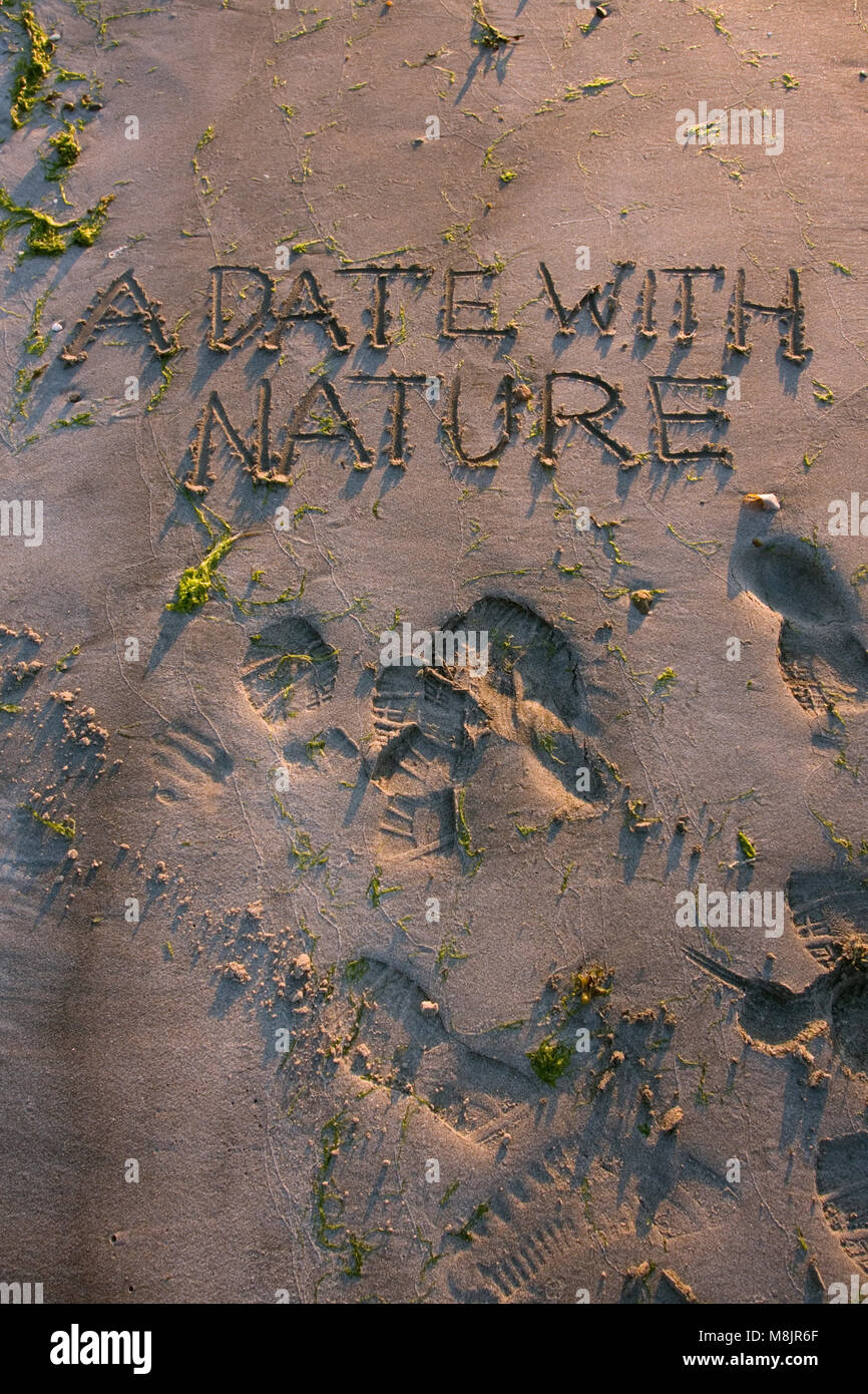 "A date with nature" handwritten in sand, Scourie bay, Scottish Highlands, June Stock Photo