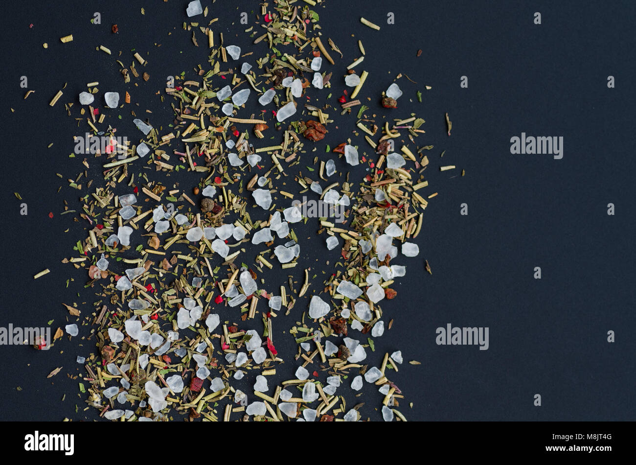 coarse grinding of sea salt. Ground spices and herbs. Dark background