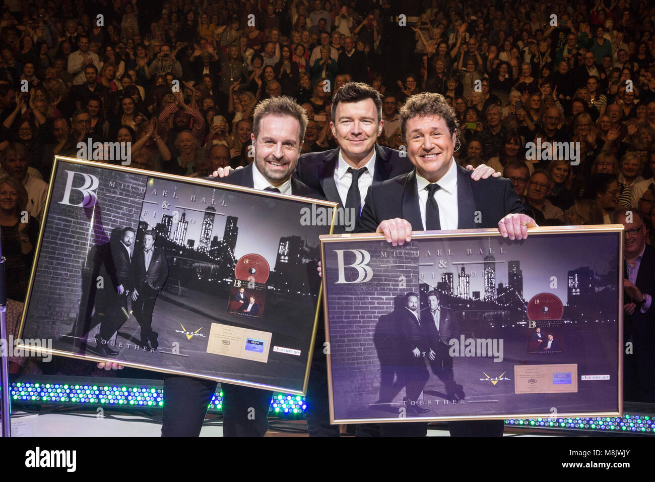 L-R: Alfie Boe, Rick Astley, Michael Ball. Rick Astley presents Michael Ball and Alfie Boe with a golden disc live on stage during their performance at the Eventim Apollo, Hammersmith. Michael Ball and Alfie Boe's album ‘Together’ went gold in just 15 days. Stock Photo