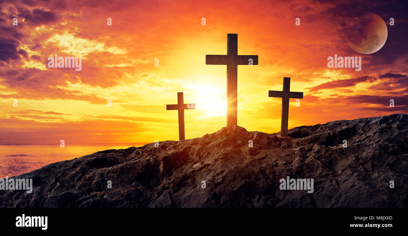 Silhouetted christian cross silhouette on the mountain at sunset Stock Photo