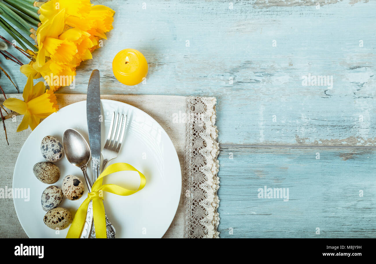 Easter table setting with daffodil, eggs and cutlery. Holidays background Stock Photo