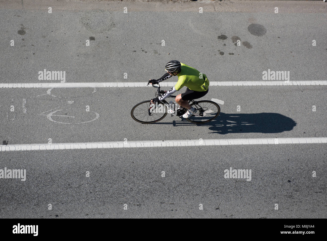 Bicyclist as seen from above traveling on the street via a bike lane, Vancouver City. Stock Photo