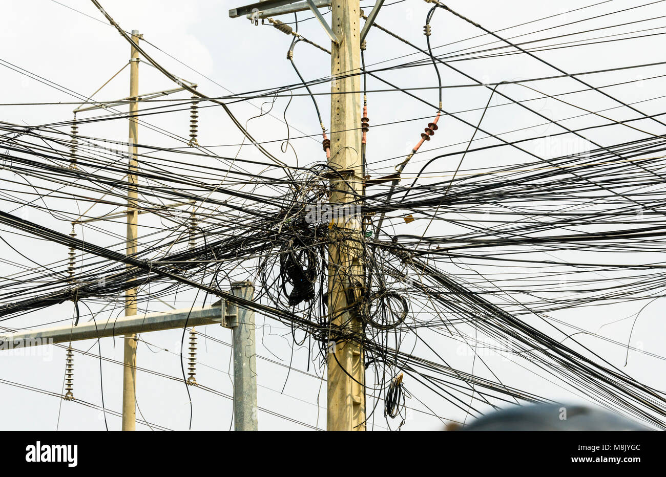 Messy tangle of electricity cables wires on an electricity supply pole