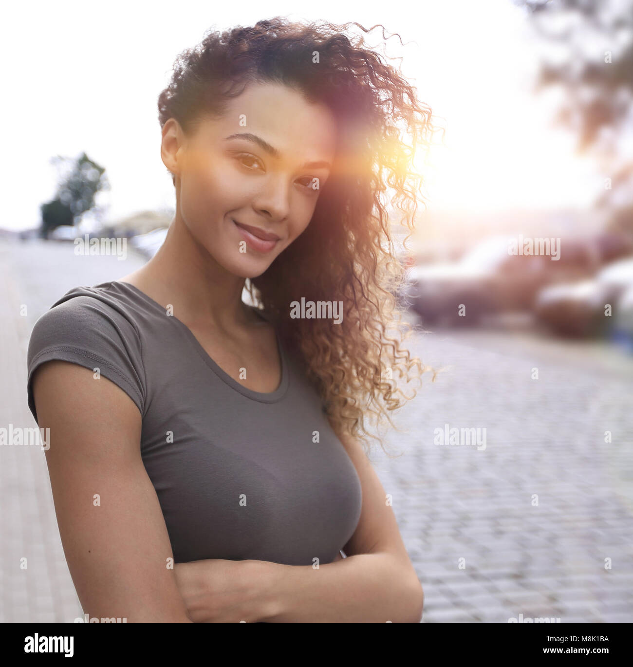 Young woman with afro hairstyle smiling in urban background Stock Photo ...