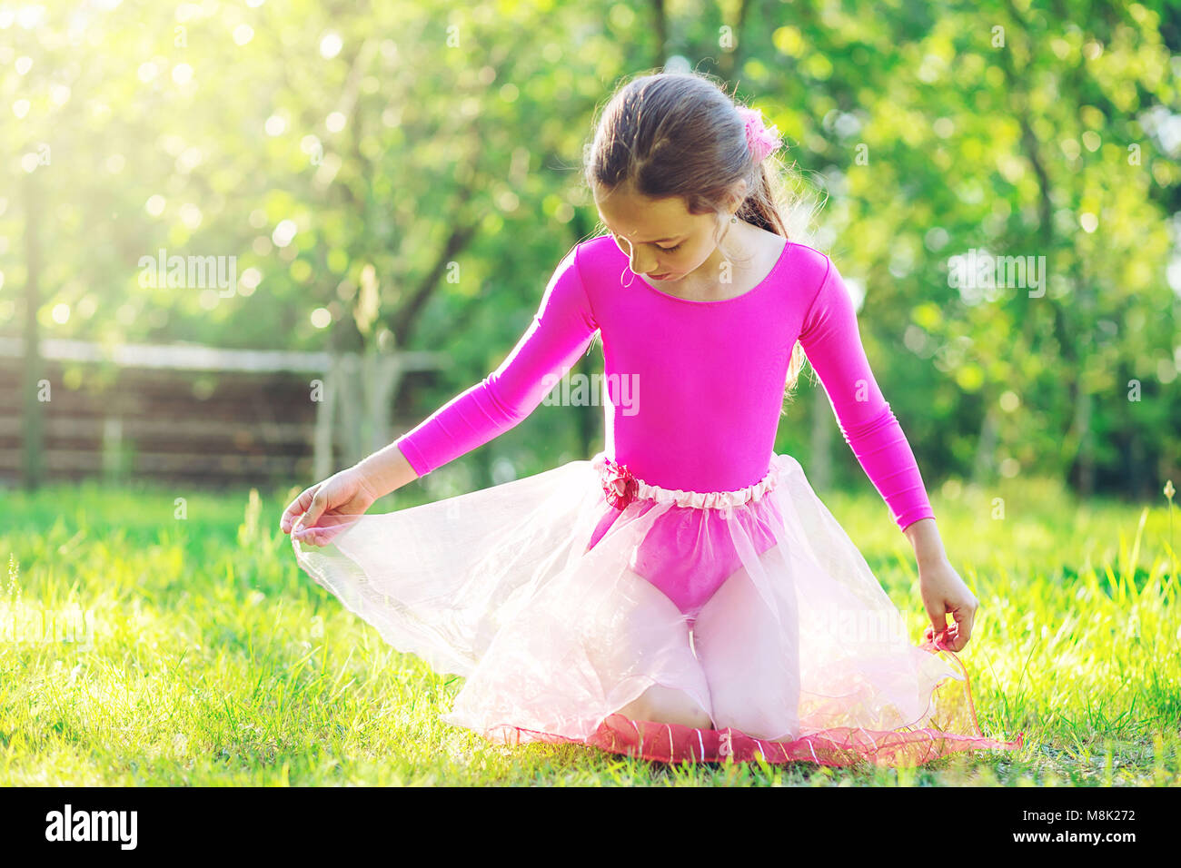 Beautiful preteen girl doing gymnastics and stretching in the city park on  summer sunset Stock Photo