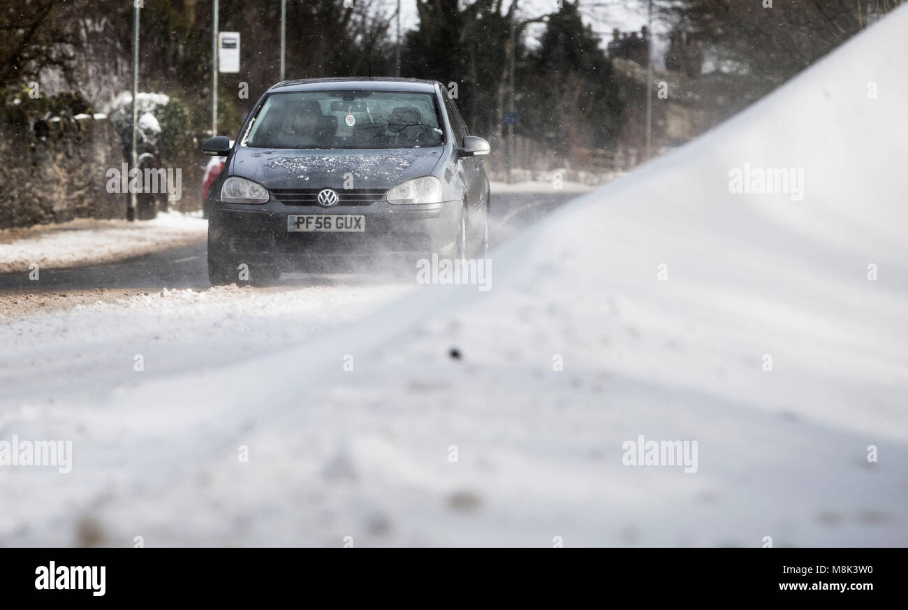 A car navigates in snow on Blackstone Edge near Littleborough in Greater Manchester where snow fell overnight as the wintry snap dubbed the 'mini beast from the east' keeps its grip on the UK. Stock Photo