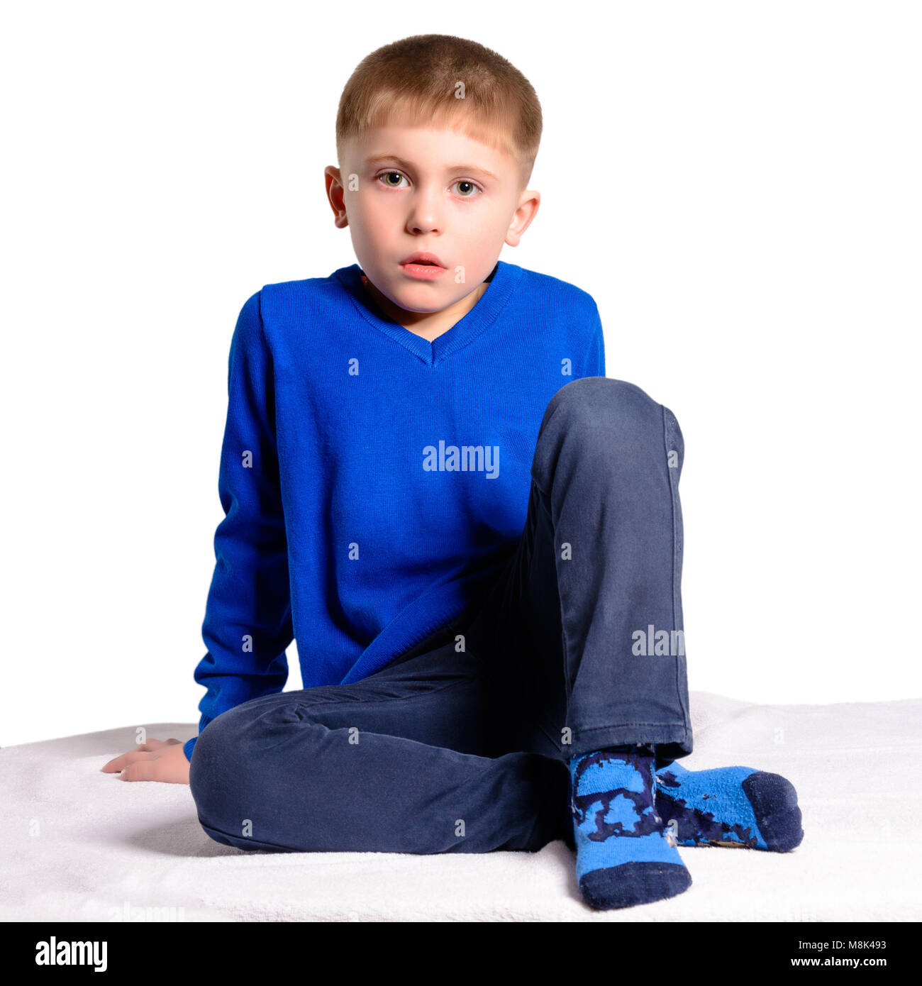 A boy in a blue jacket sits, isolated on a white background Stock Photo ...