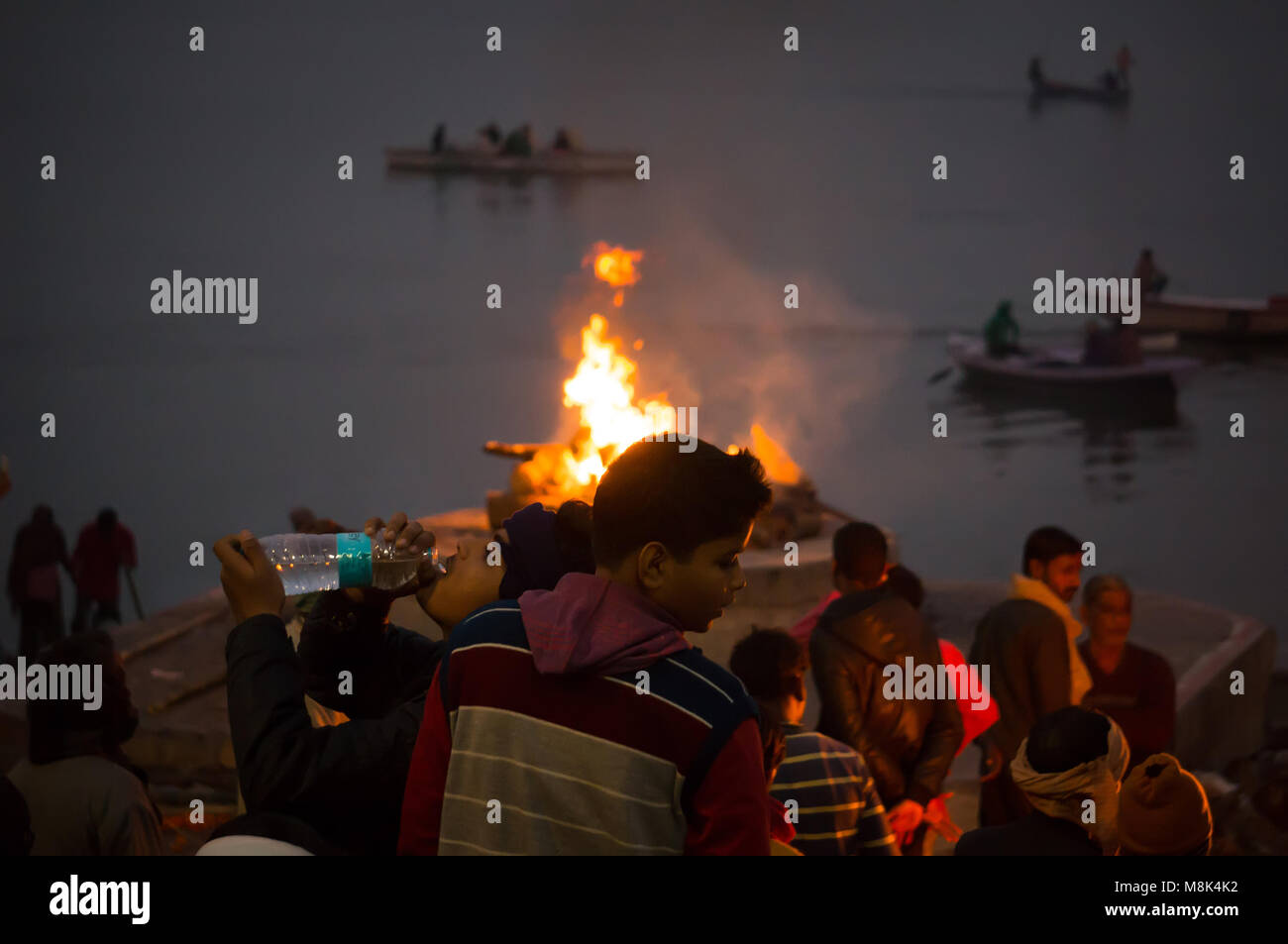 VARANASI, INDIA. February 28, 2017: People look at the funeral pyre that night. The ceremony of the cremation of Manikarnika Ghat on the banks of the  Stock Photo